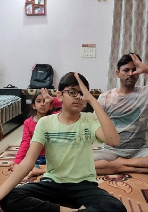 A person and two children doing yoga indoors