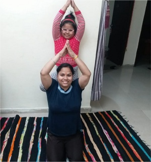 A person and a child doing yoga on a colorful rug