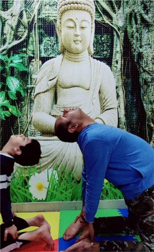 People doing yoga in front of a Buddha statue
