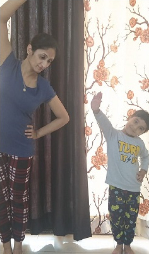 A person and a child doing yoga indoors